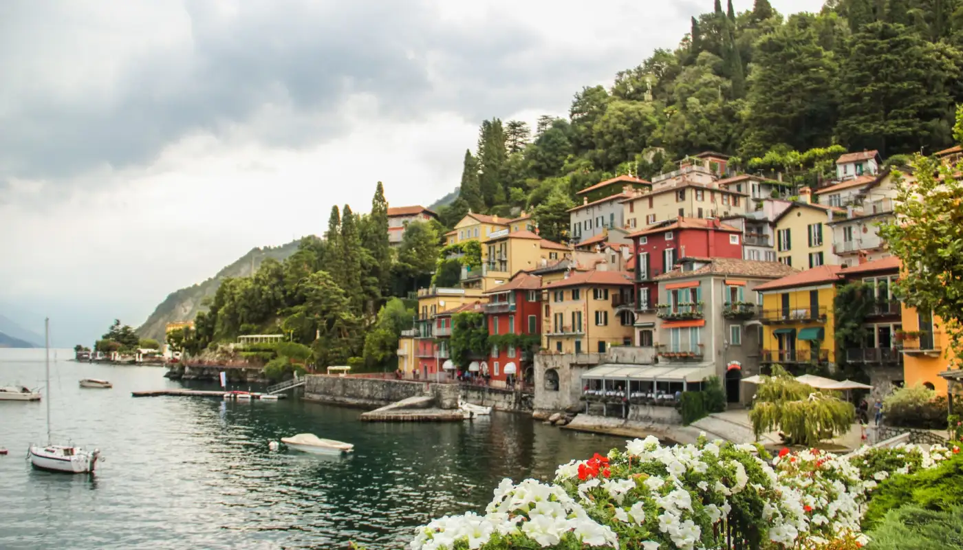 Le village de Varenna au bord du lac de Côme, maisons colorées et voiliers devant les montagnes