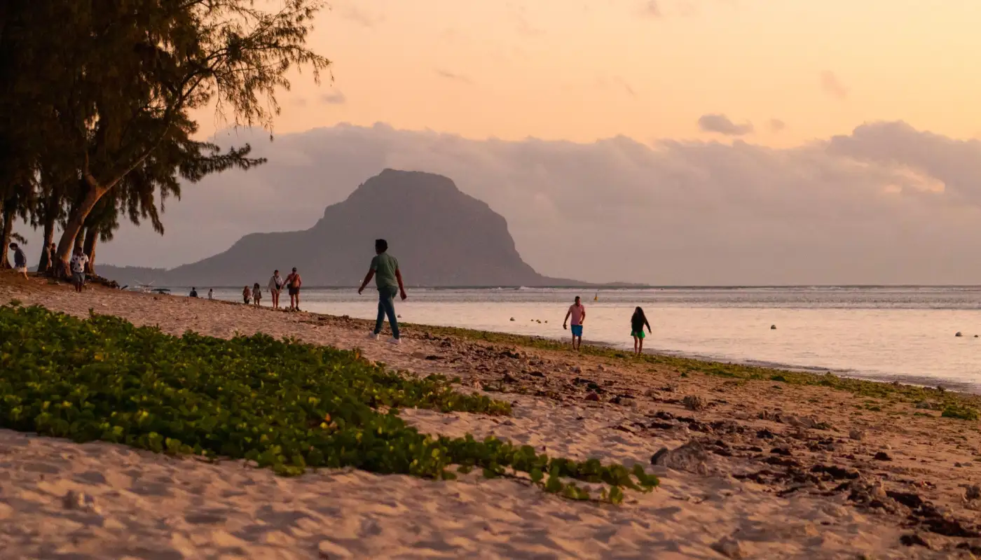 Coucher de soleil sur la plage de Flic en Flac, côte ouest de l'île Maurice, avec la silhouette du Morne Brabant à l'horizon